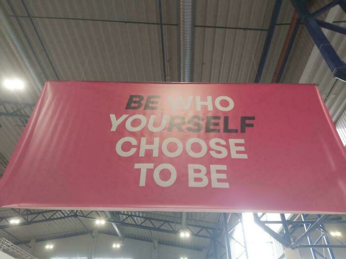A hanging banner with a confusing design fail, reading BE WHO YOURSELF CHOOSE TO BE.