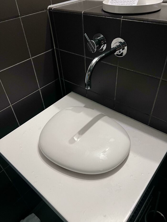 Hilariously awful design fail: A bathroom sink with an awkward, flat design causing water to pool, a clear design fail.