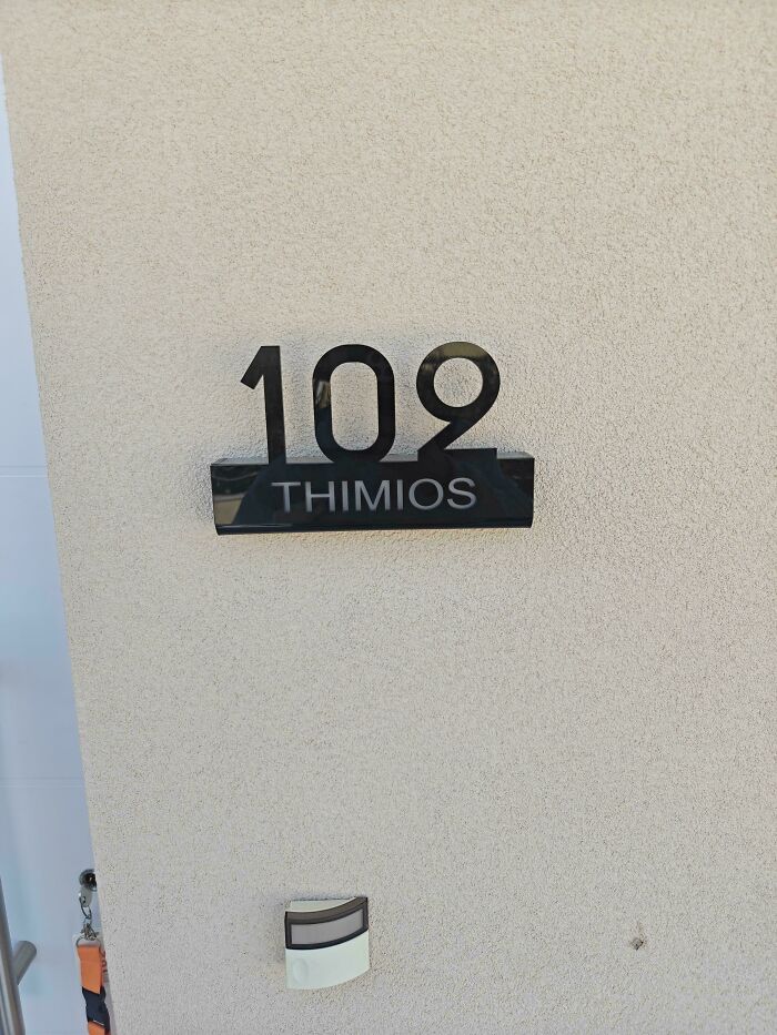 House number 109 with the name THIMIOS below, where the 109 casts a shadow that makes it look like it says Thimios above. An awful design fail.