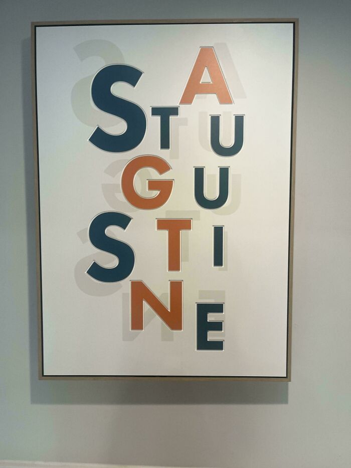 A hilariously awful design fail with the word AUGUSTINE vertically spelled as STU GU STI NE with orange and blue letters.