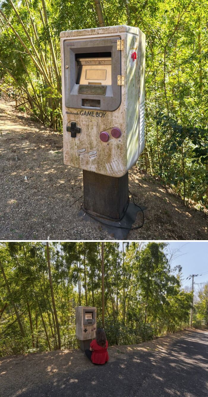 Urban explorers found an unexpected, giant, weathered Nintendo Game Boy structure amidst lush greenery.