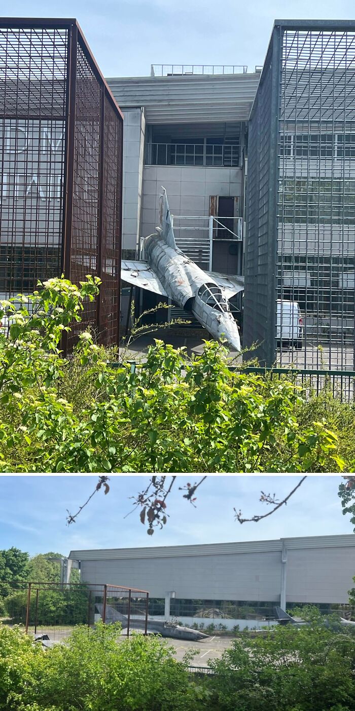 Urban explorers stumbled upon an old fighter jet displayed between modern buildings, an unexpected sight.
