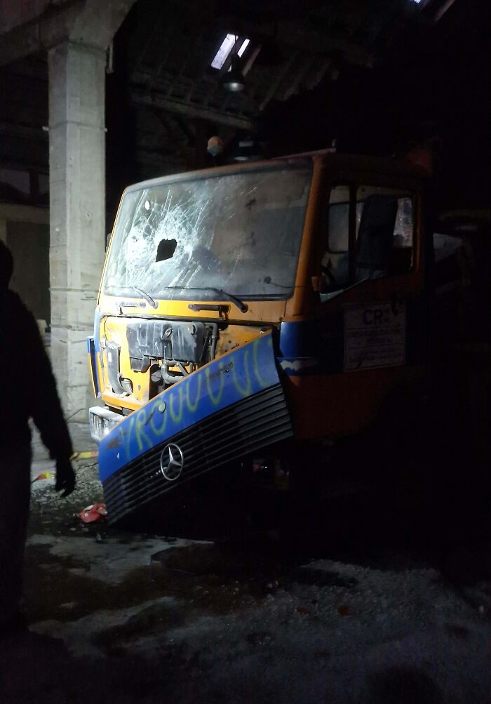 Urban explorers found an unexpected, dilapidated truck with a broken windshield inside a dark, abandoned structure.