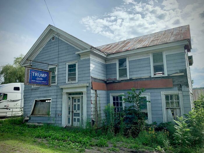 An old, rundown house with a 'Trump 2020' sign hanging outside, displaying different photos of USA.