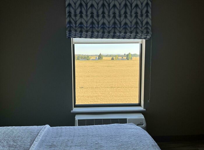 Photos of the USA: a scenic view of a vast golden field stretching to the horizon, seen from a hotel room window.