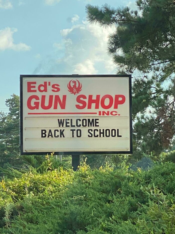 A sign for Ed's Gun Shop, Inc. with a Welcome Back to School message, showing the USA's unique contrasts.