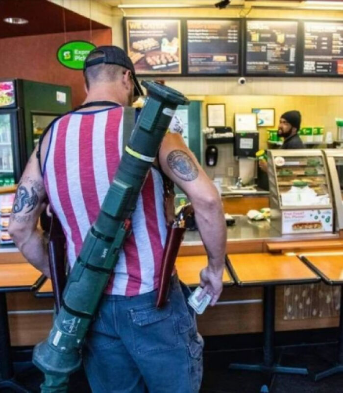 Photos of the USA: A man in a striped shirt carrying a rocket launcher and knives in a sandwich shop.