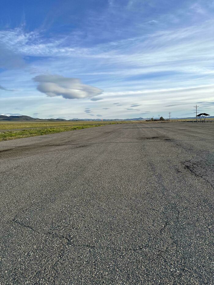 Fascinating and different photo of a vast, empty road in the USA under a big sky, highlighting the country's diverse landscapes.