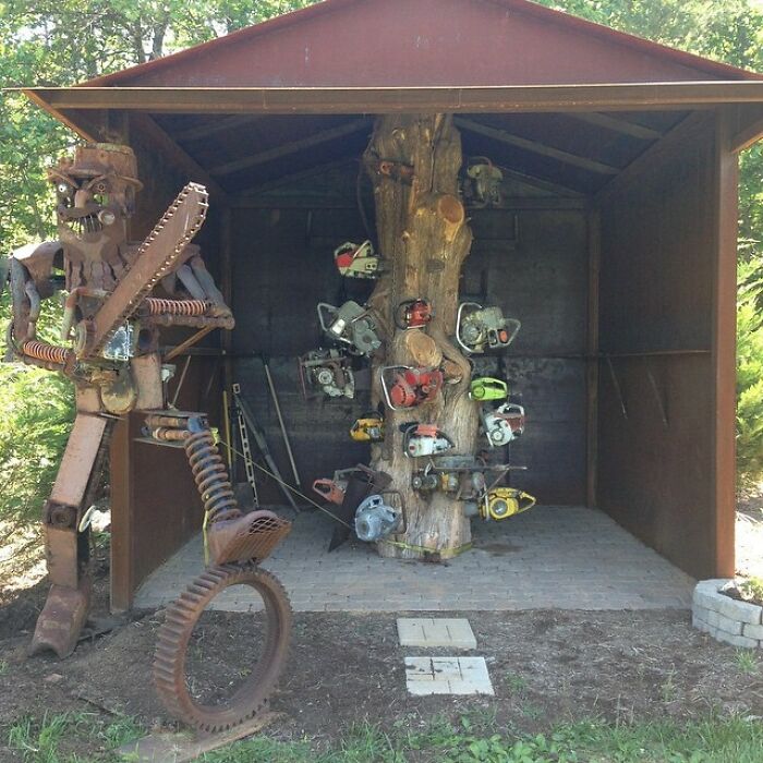 A unique metal sculpture of a chainsaw-wielding robot next to a tree adorned with chainsaws, representing the diverse USA.