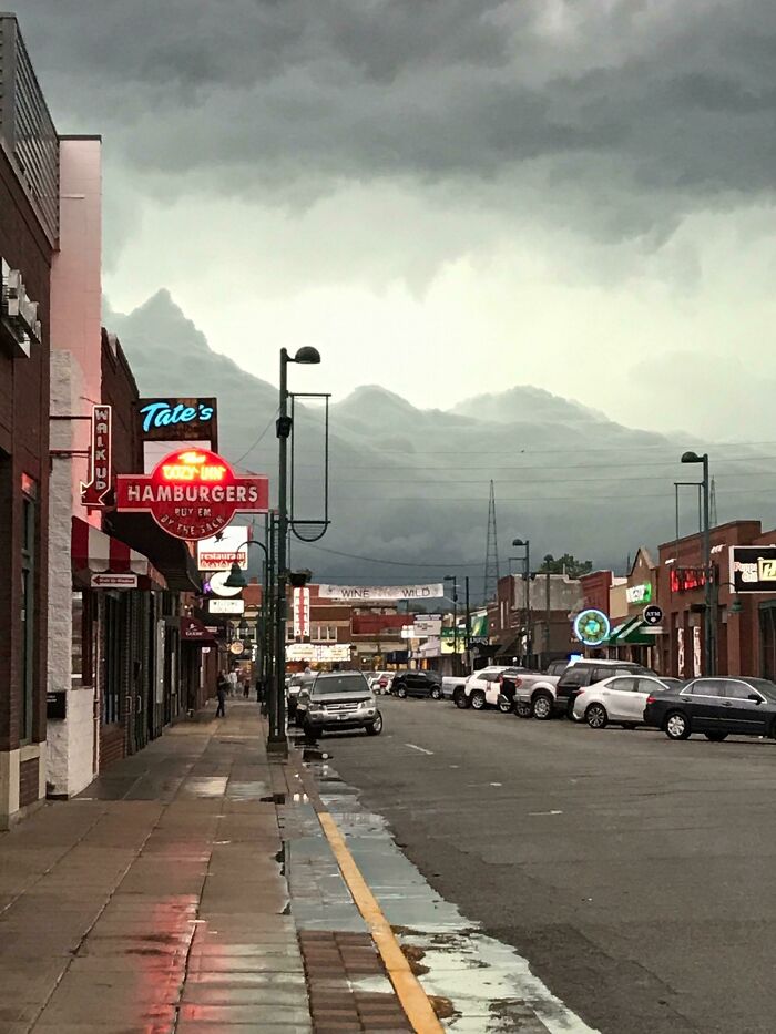 A street scene under dramatic clouds, one of the fascinating and wildly different photos of the USA.