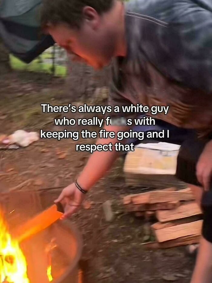 A man stoking a campfire, an example of people being funny and specific about their dedication.