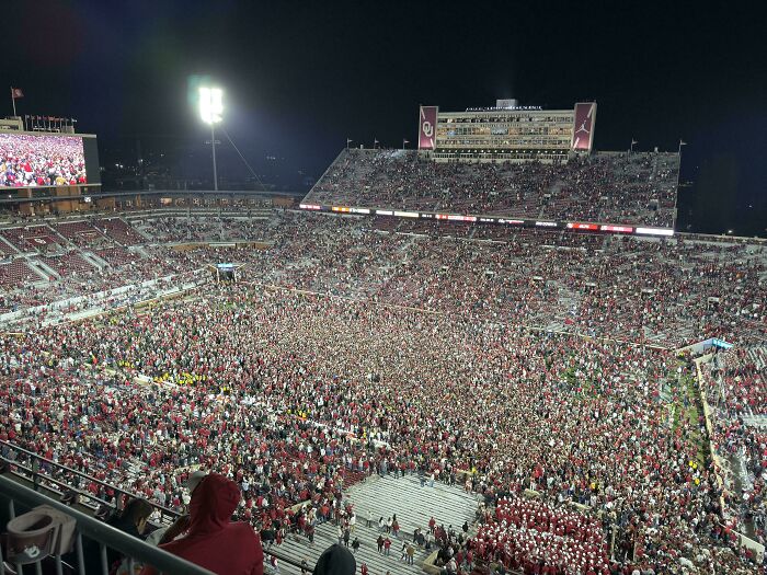 An aerial view of a packed football stadium at night in the USA, a fascinating and different photo.