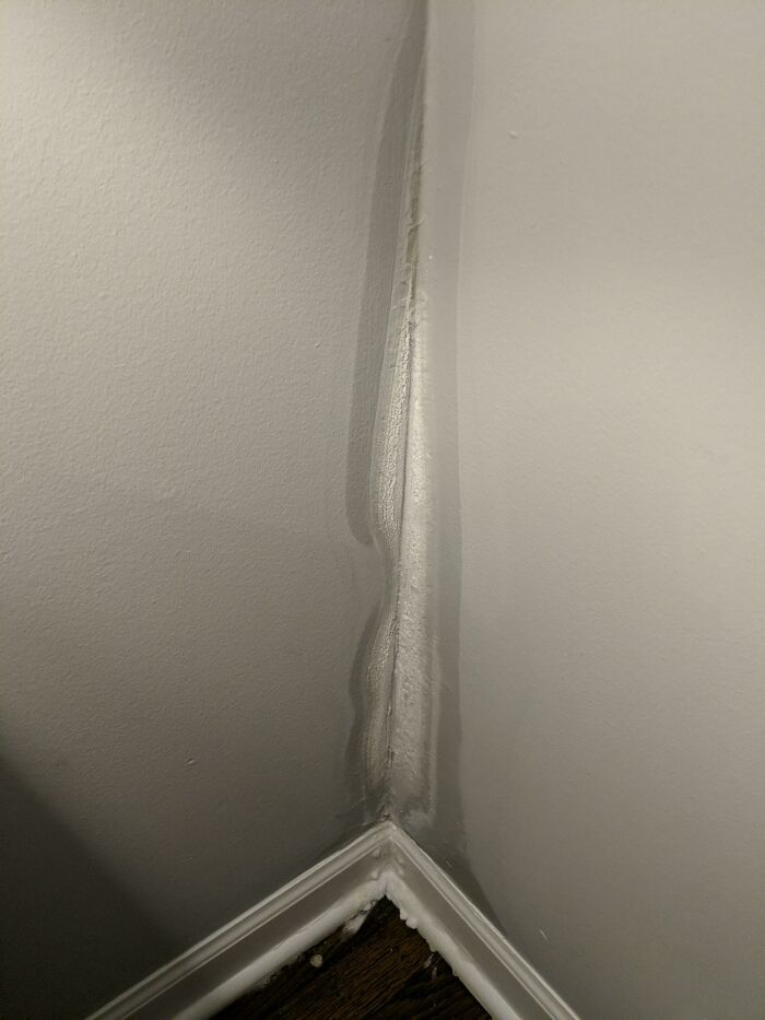 A corner of a room with a noticeable water leak and damage, revealing a unique side of the USA.