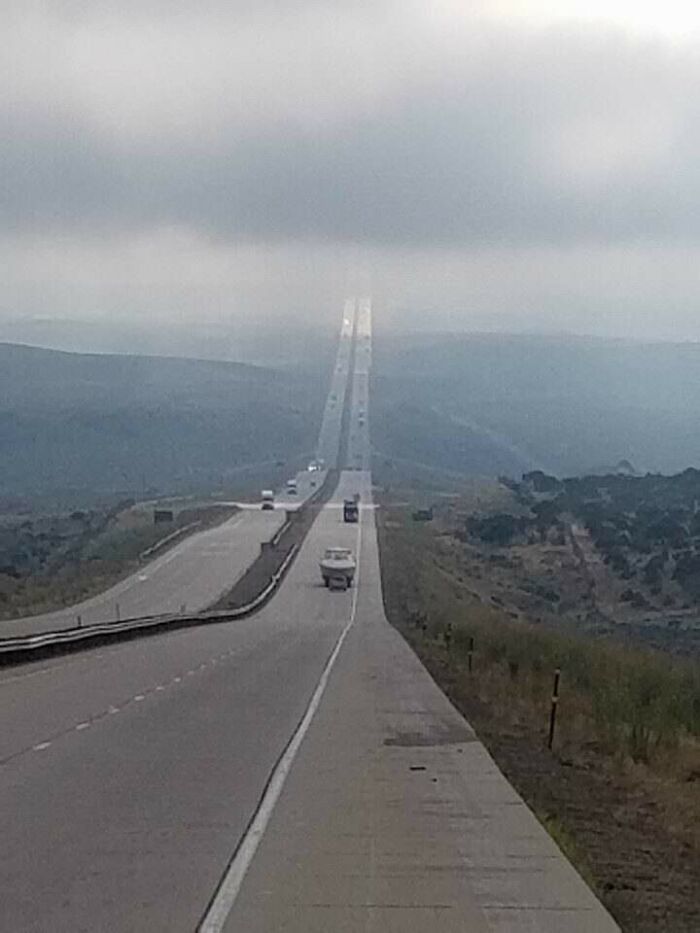A long, straight highway stretching into the misty distance, highlighting the varied photos of the USA.