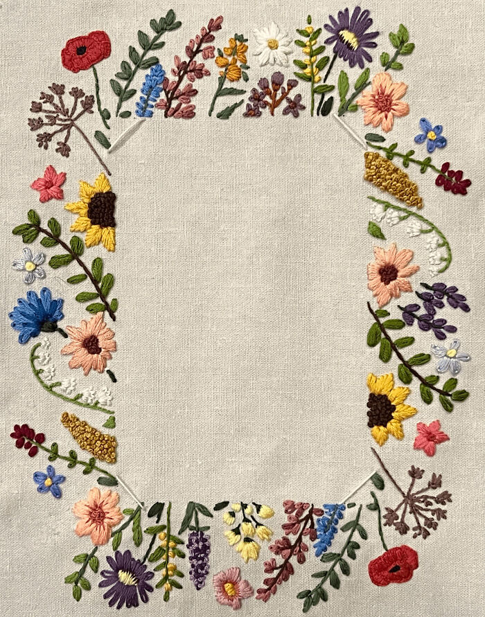 A beautiful border of colorful wildflowers stitched on fabric, showcasing creative embroidery projects
