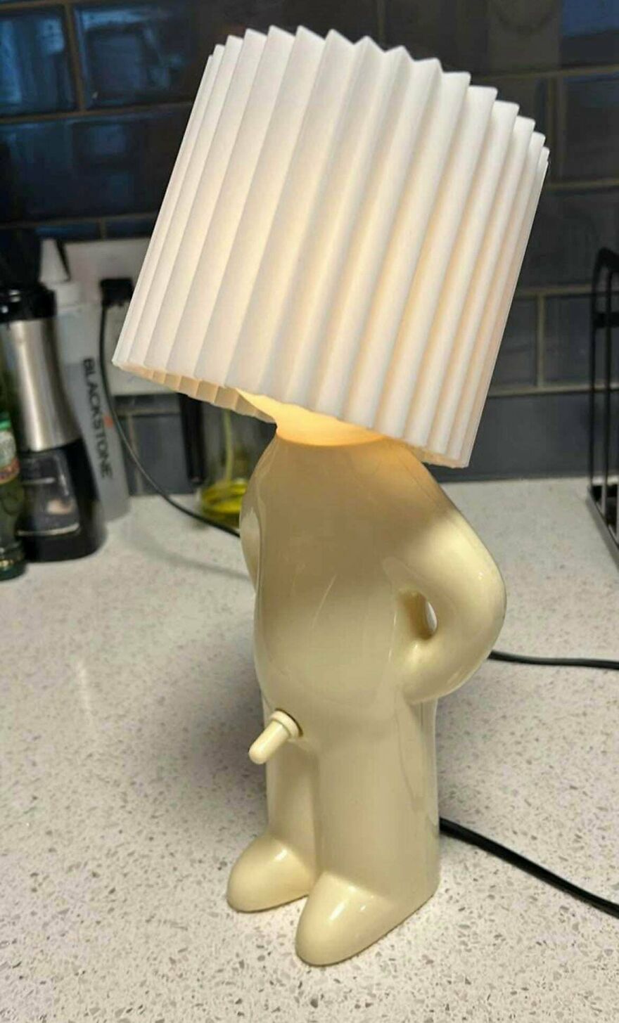 An amusing, phallic-shaped lamp with a pleated shade, perfect for a chuckle and improving your day.