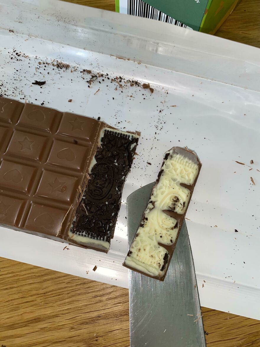 A chocolate bar with a piece cut out, revealing a creamy, cookie-filled interior, among amusing things.