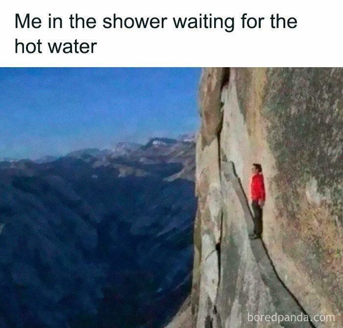 A person in a red jacket stands precariously on a narrow cliff ledge, an ancient meme about waiting for hot water.