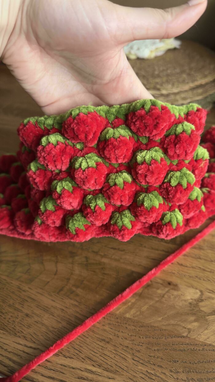 Close-up of red and green crochet piece resembling strawberries