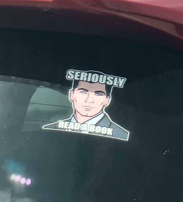 Funny bumper sticker featuring Archer saying, SERIOUSLY READ A BOOK on a car window.
