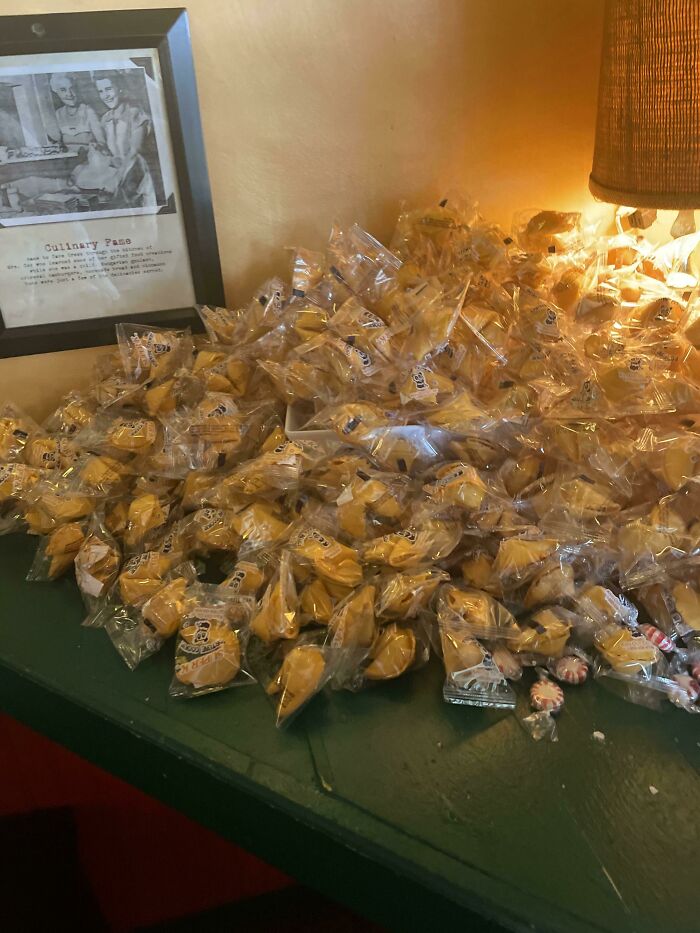 A surprisingly simple and genius idea, a large pile of individually wrapped fortune cookies on a table.