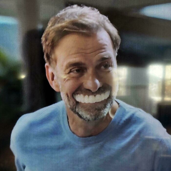 A man with a wide smile showing very white teeth, likely from a commercial.