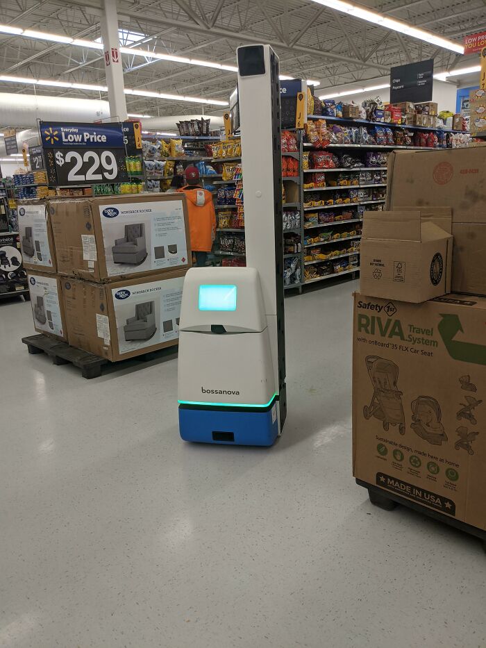 A tall Bossa Nova robot navigating a supermarket aisle, a genius idea solving everyday problems with technology.