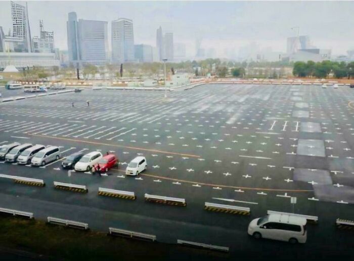 A vast, nearly empty parking lot with a Genius Idea for solving Everyday Problems by marking parking spots in a unique way.