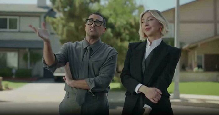 Two people, a man gesturing and a woman smiling, standing outside a house, featured in commercials.