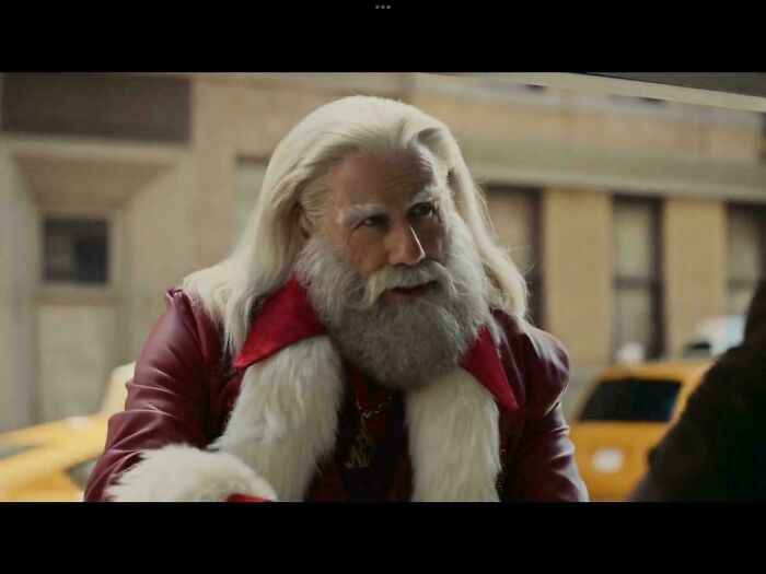 A modern Santa Claus with long white hair and a beard, wearing a red leather jacket, from commercials people cant stand.