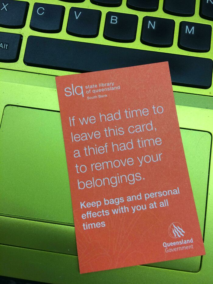 An orange card with a theft warning on a bright green laptop keyboard, a simple solution to an everyday problem.