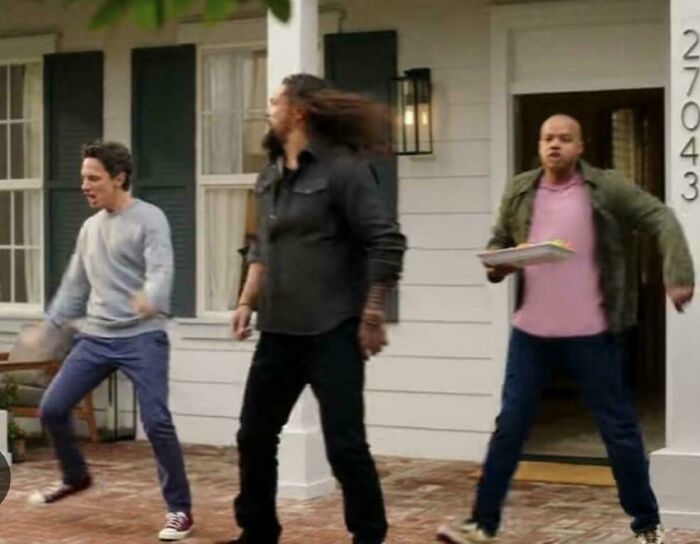 A group of men dancing in front of a house, one carrying a plate, featured in commercials people can't stand.