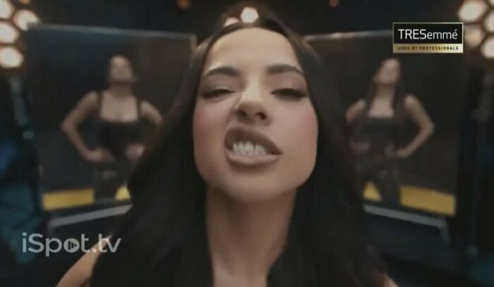 A woman with long dark hair, making a fierce face, in a TRESemmé commercial that people cant stand.