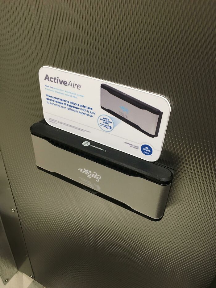 An ActiveAire automated in-stall air freshener on a textured wall, representing a simple and genius solution for businesses.