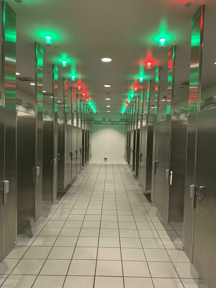 A restroom showing clever genius ideas with red and green lights above stalls to indicate occupancy, solving everyday problems.