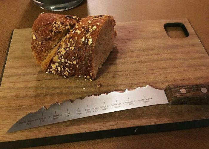 A unique serrated bread knife featuring mountain peak designs on a wooden cutting board with a sliced loaf of bread, an example of genius ideas.