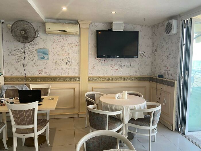 A cozy cafe interior with white walls covered in customer notes, a business with genius ideas for everyday problems.