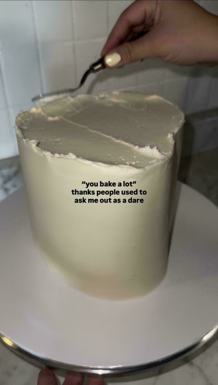A hand frosting a cake with white icing, revealing unhinged things people shared about baking and dating.