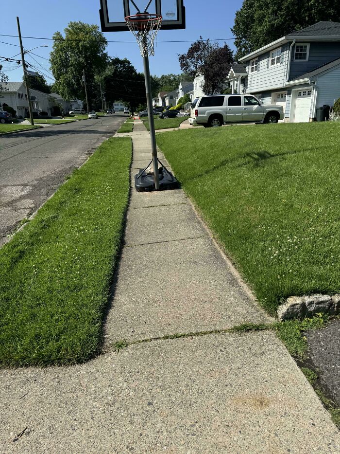 A basketball hoop with its base completely blocking a sidewalk, a classic example of thinking they're the main character.