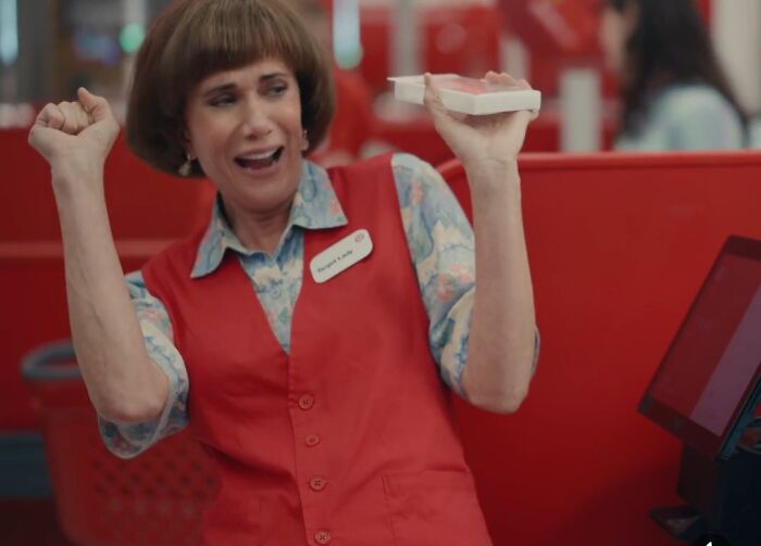 Woman in a red vest enthusiastically holding cards, representing commercials people can't stand.