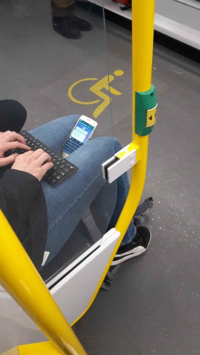A person using a mini keyboard and smartphone on a bus, showing a blursed meme scenario.