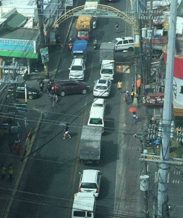 Overhead view of a busy street with cars and people, a blursed meme for laughter.