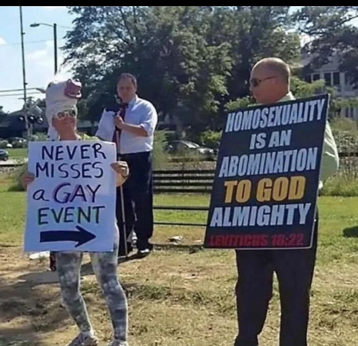 A blursed meme of two people protesting; one sign says Homosexuality is an Abomination to God, another Never Misses a Gay Event.