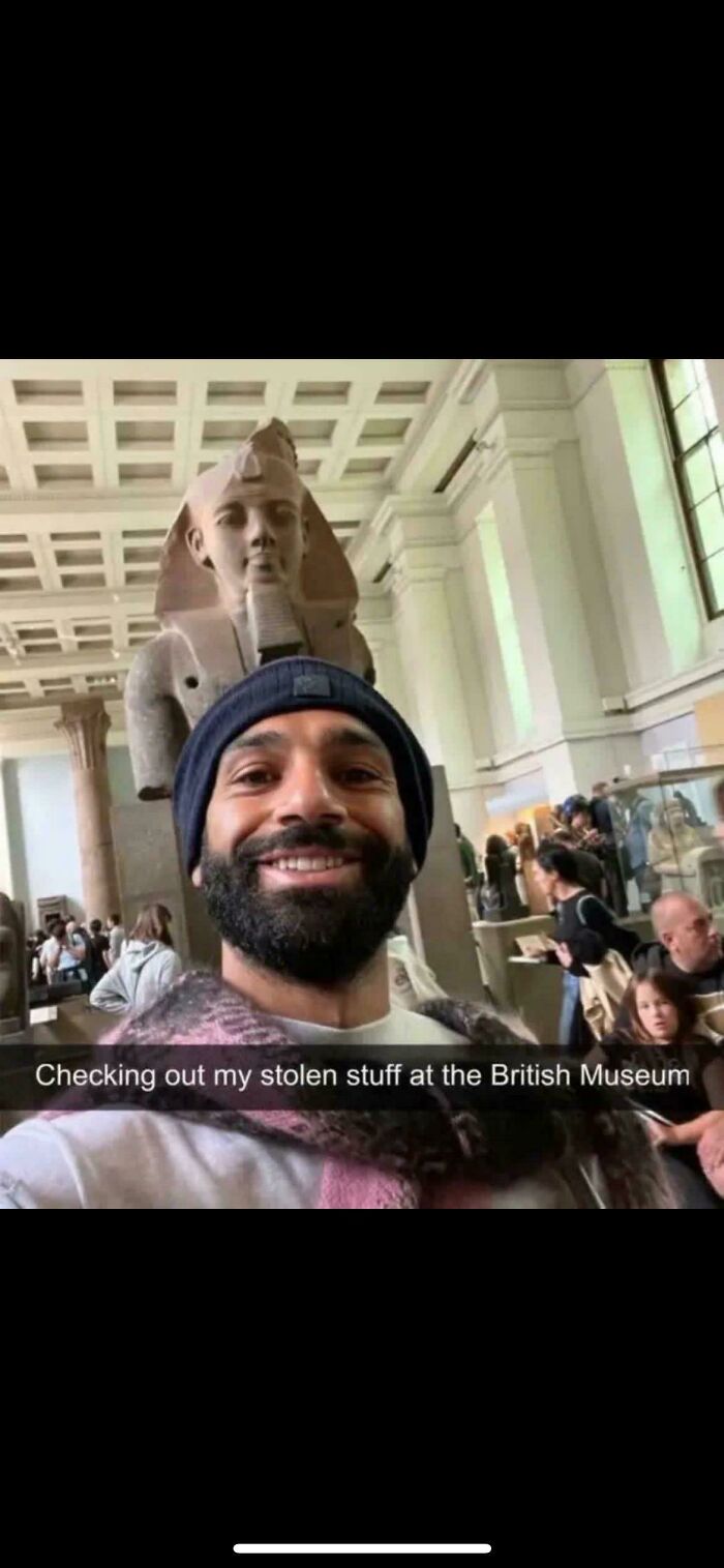 A smiling man taking a selfie with an ancient statue, captioned Checking out my stolen stuff at the British Museum, a blursed meme.