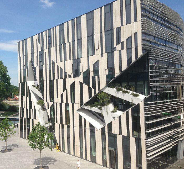 A unique modern architecture design with an asymmetrical facade and green terraces.