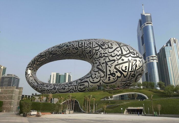 Amazing and beautiful modern architecture designs feature a futuristic, oval-shaped building adorned with Arabic calligraphy.