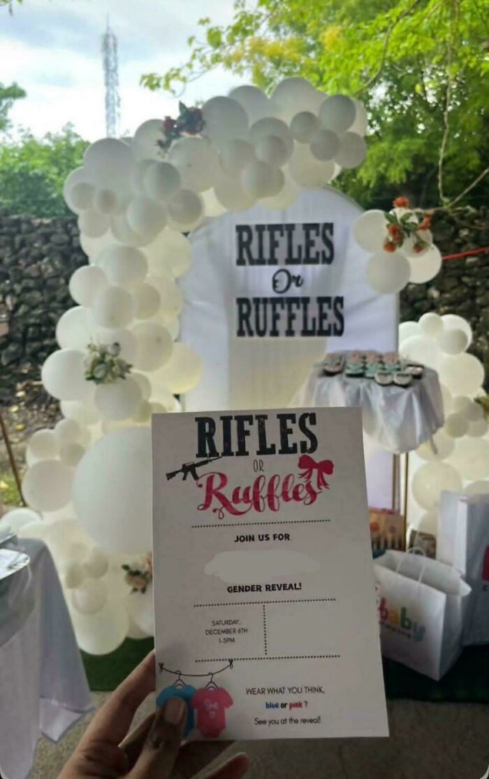 A gender reveal party setting with a Rifles or Ruffles theme, featuring a white balloon arch and an invitation.