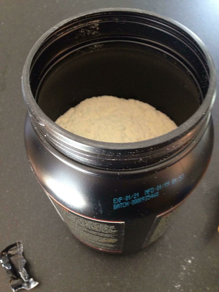 A partially filled black container of powder, demonstrating marketing practices that infuriated customers with the quantity.