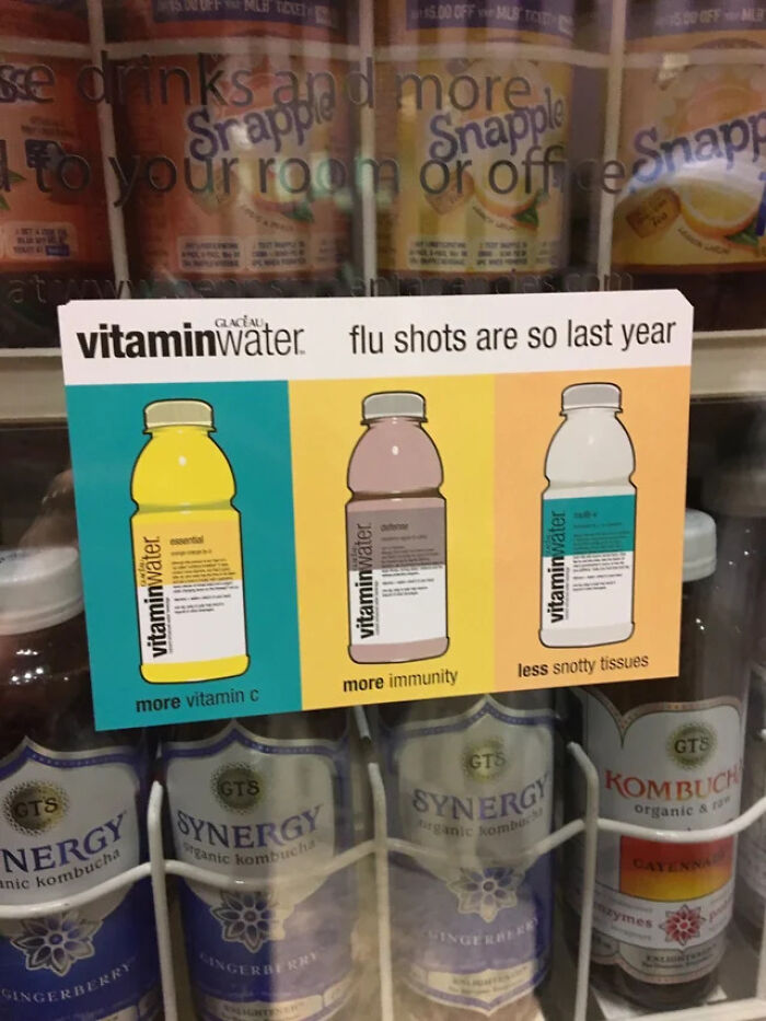 An infuriating marketing practices display for Vitaminwater, suggesting it's an alternative to flu shots, with bottles claiming 'more vitamin C', 'more immunity', and 'less snotty tissues'.