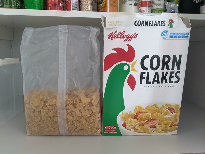 A Kellogg's Corn Flakes box next to a clear bag filled with only a small portion of cereal, illustrating infuriating marketing practices.